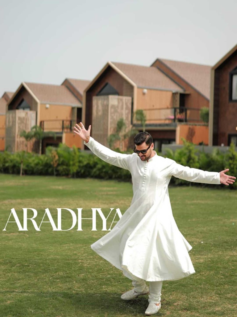 Groom celebrating on the lawn at Beverly Hills with resort villas in the background